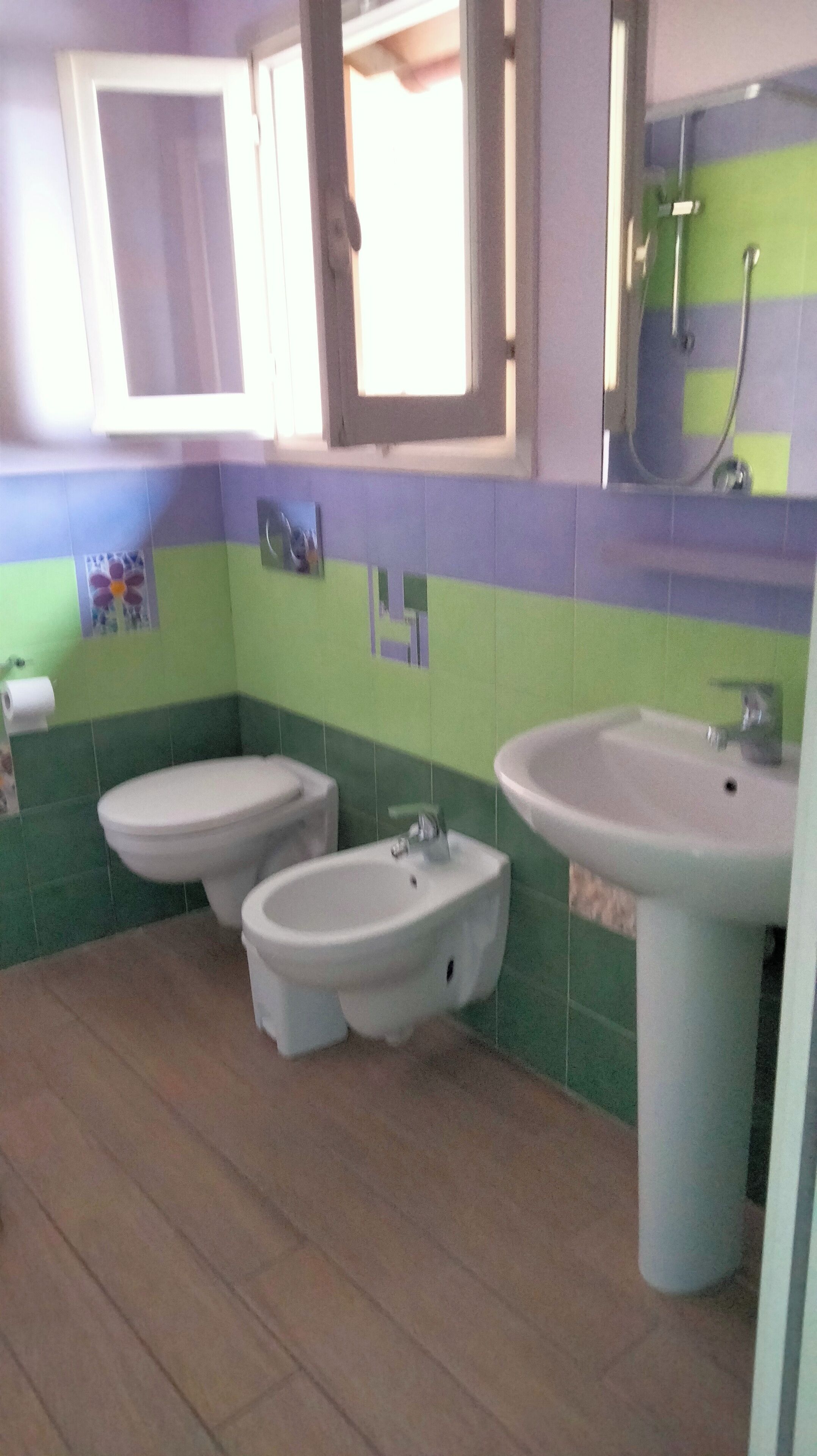 Ein Badezimmer mit zwei Toiletten, einem Waschbecken und einem Spiegel.