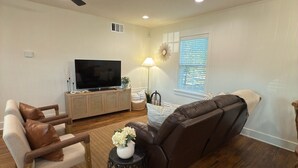 A living room with a sofa, armchair, TV, and a ceiling fan. - 3 bedroom house just 1 mile from the heart of historic downtown Waxahachie! (Waxahachie)