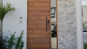 Ein modernes Gebäude mit einer Holztür, Hausnummer 17, und einer Ziegelwand.