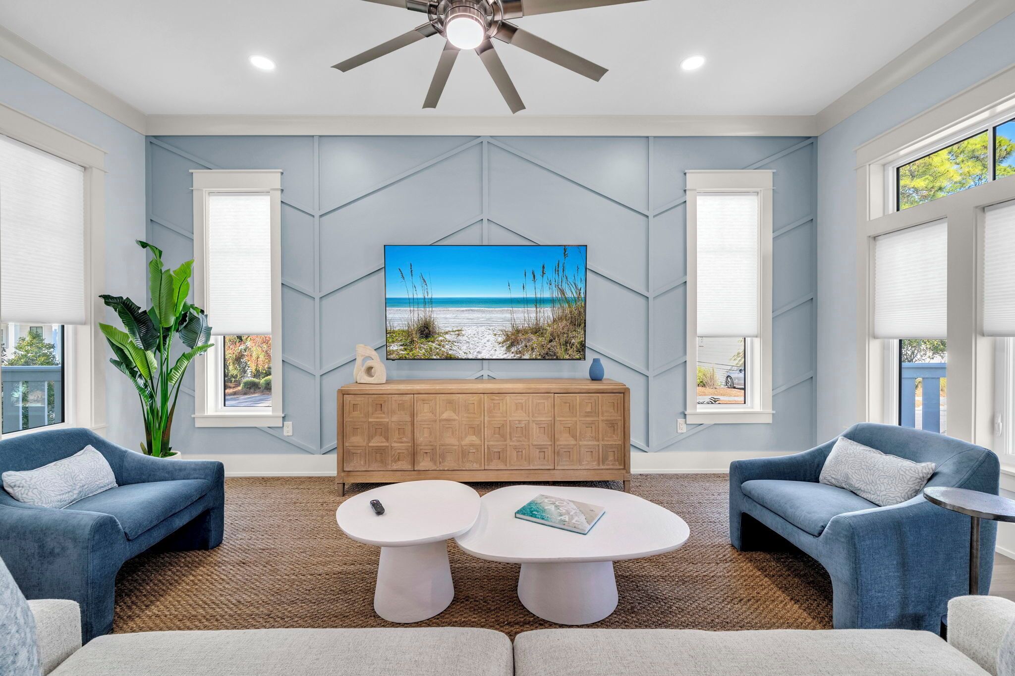 A modern living room with a large TV, two sofas, a coffee table, and a wooden cabinet.