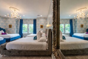 Ein Hotelzimmer mit zwei Betten, einem großen Spiegel und einer Kristallleuchter.