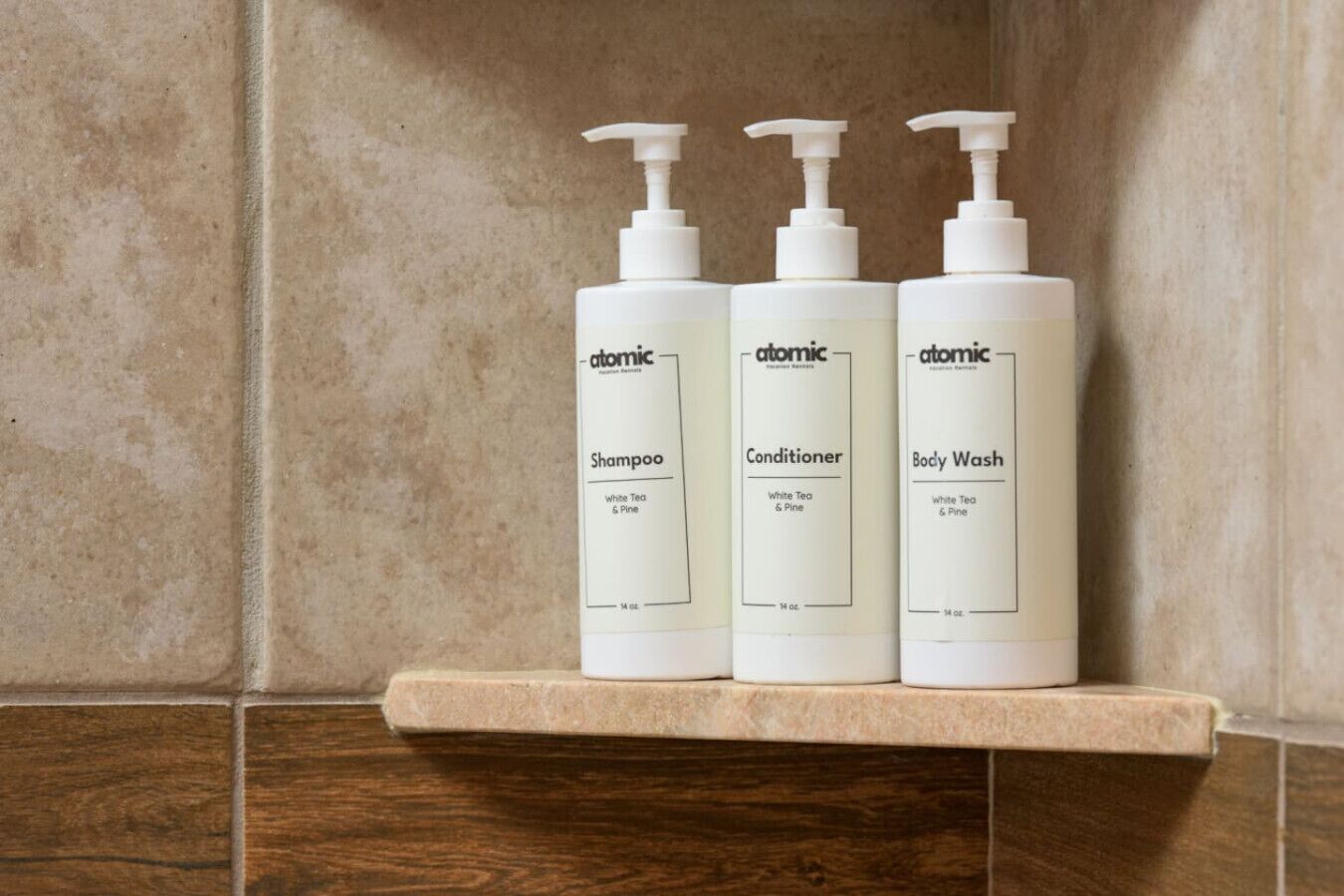Three bottles of Atomic brand personal care products on a shelf.
