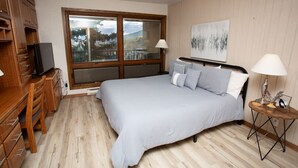 A bedroom with a large bed, wooden wardrobe, and a TV. - 10 Steps to the Slopes! Unbeatable Ski-In/Ski-Out! Hot Tub! (Mount Crested Butte)