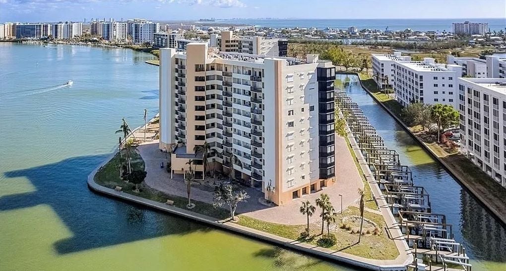 A high-rise hotel with multiple floors, a waterfront promenade, and a marina.