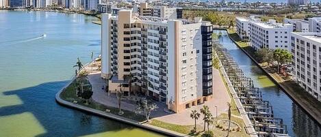 A high-rise hotel with multiple floors, a waterfront promenade, and a marina.