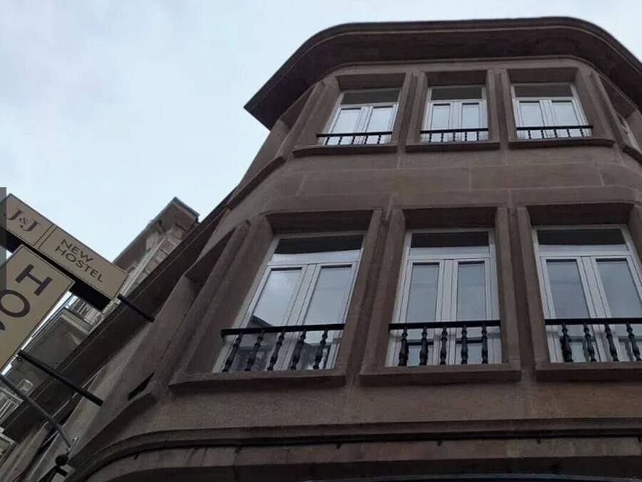 Ein mehrgeschossiges Gebäude im klassischen Stil, mit einem Balkon im zweiten Stock.