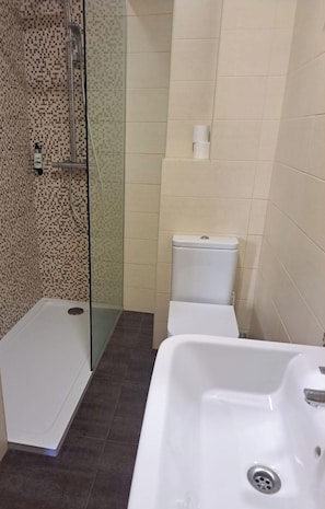 A bathroom with a shower, toilet, and sink. - NEW JJ HOSTEL (Ourense)