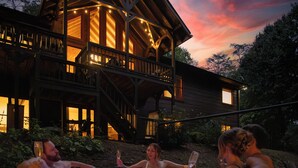A wooden cabin with a hot tub and a balcony overlooking a forested area. - The Hidden Still~Blue Ridge Speakeasy Lakehouse~SLEEPS 22 (Cherry Log)