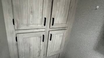 A bathroom with a wooden wardrobe, a toilet, and a marble sink.