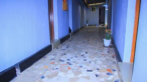 A hallway with blue walls and a mosaic tile floor. - HAPPY CLASSIC LODGE MBEYA (Mbeya)