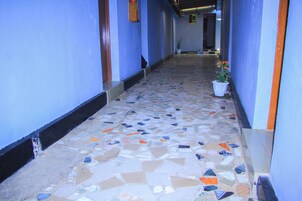 A hallway with blue walls and a mosaic tile floor.