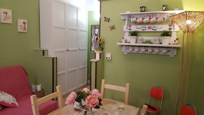 A cozy room with a dining table, chairs, a red sofa, a white wardrobe, and a shelf with decorative items. - Cicci's house (Cefalù)