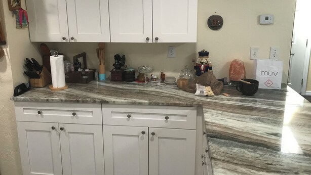 A kitchen with white cabinets, a marble countertop, and various kitchen items. - Tampa Lakehouse 6-bedroom houses on a acre (Tampa)