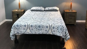 A bedroom with a bed, two nightstands, two lamps, a ceiling fan, and a wall-mounted painting. - Tampa Lakehouse 6-bedroom houses on a acre (Tampa)