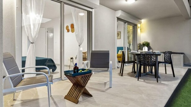 Un espacio al aire libre con mesa y sillas, un banco y una mesa decorativa de madera.