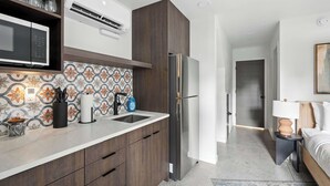 Una cocina moderna con microondas, pileta y refrigerador de acero inoxidable.
