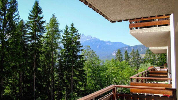 A wooden staircase leading to a balcony with a view of a forest and mountains. - Ca Del Molin in Cortina d Ampezzo (Cortina d'Ampezzo)