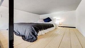 Una camera da letto con un letto, un comodino e una lampada.