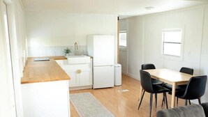 A compact kitchen with white cabinets, a wooden countertop, and a small refrigerator. - -The Villa On The Lake- (Groveland)