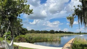A serene outdoor area with a wooden deck, a hammock, and a pond. - -The Villa On The Lake- (Groveland)