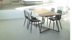 A modern, minimalist room with a large bed, built-in shelving, and a dining area with a table and chairs.