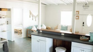 A spacious kitchen with white cabinetry, a black countertop, and a wooden dining area.