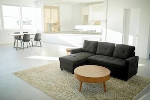 A modern living room with a sectional sofa, a round coffee table, and a patterned rug. - -The Gathered Place- (Groveland)