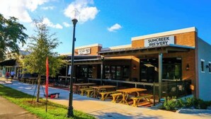 A building with a sign reading "Suncreek Brewery" and outdoor seating.