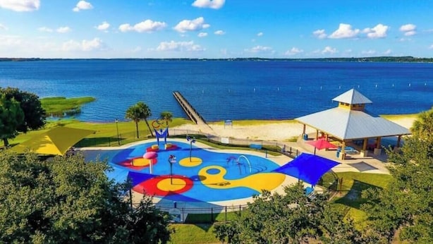 A water park with a large pool, slides, and a gazebo.