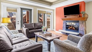 Una sala de estar con chimenea, un sofá, una mesa de centro y un televisor.