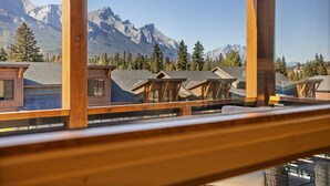 A view from a balcony overlooking a mountain range with multiple chalet-style buildings. - Serenity Awaits | Mountain Views (Canmore)
