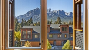 A view through a window of a building with a mountain backdrop. - Serenity Awaits | Mountain Views (Canmore)