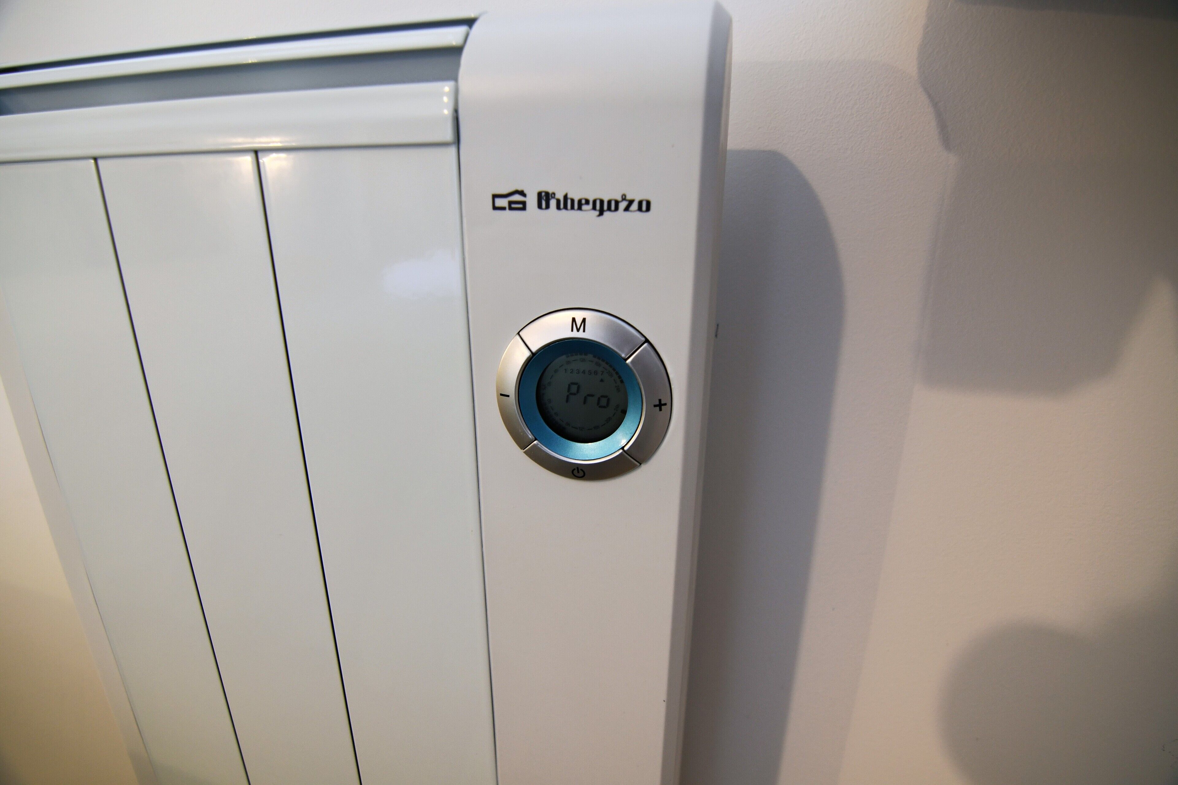 Een thermostaat met een digitaal display en een bedieningsknop, met de aanduiding 'Orbeozo'.