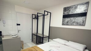 Una camera d'albergo con un letto, una scrivania, una sedia, un armadio e un bagno.