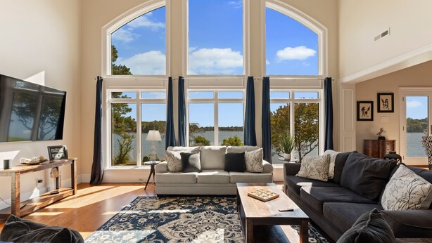 A spacious living room with a large window, a sofa, a coffee table, and a TV.