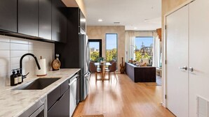 Una cucina moderna con mobili scuri, un piano di lavoro in marmo e un'area pranzo con vista.
