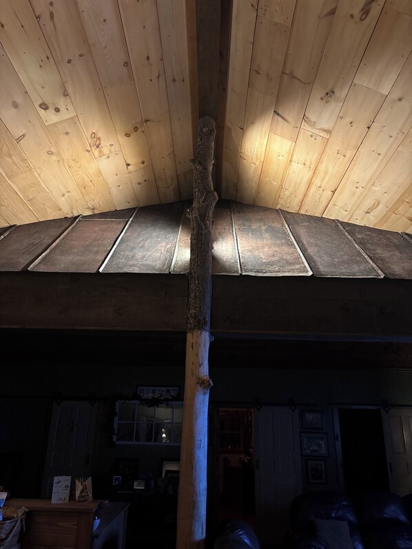 Eine Holzbalkendecke mit einem zentralen Träger und einer geneigten Dachkonstruktion.
