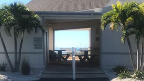 A private property with a clear view of the beach, a picnic area, and a sign indicating no pets are allowed. - Charming 2-bedroom condo overlooking Sarasota Bay on Longboat Key (Longboat Key)