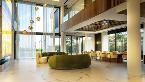 A spacious lobby with a high ceiling, large windows, and a modern seating area. - Villa Harmonie Luxe & Bien-être in the golf residence with spa (Marrakech)
