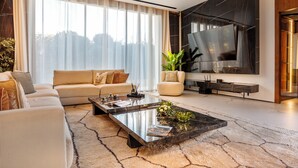 Ein modernes Wohnzimmer mit einer Couch, einem Couchtisch und einem großen Flachbildfernseher.