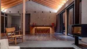 Un interno moderno con soffitto in legno, un angolo bar e un camino.