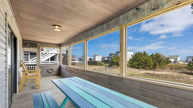 A covered porch with wooden benches and a view of the surrounding area. - Little Island Time: Walk to Beach Retreat (Kitty Hawk)