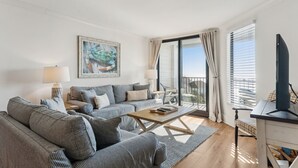 Een moderne woonkamer met een bank, salontafel en televisie.