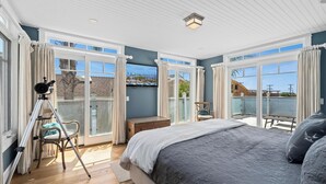 Ein Schlafzimmer mit einem großen Bett, einem Teleskop und einem Balkon mit Blick.