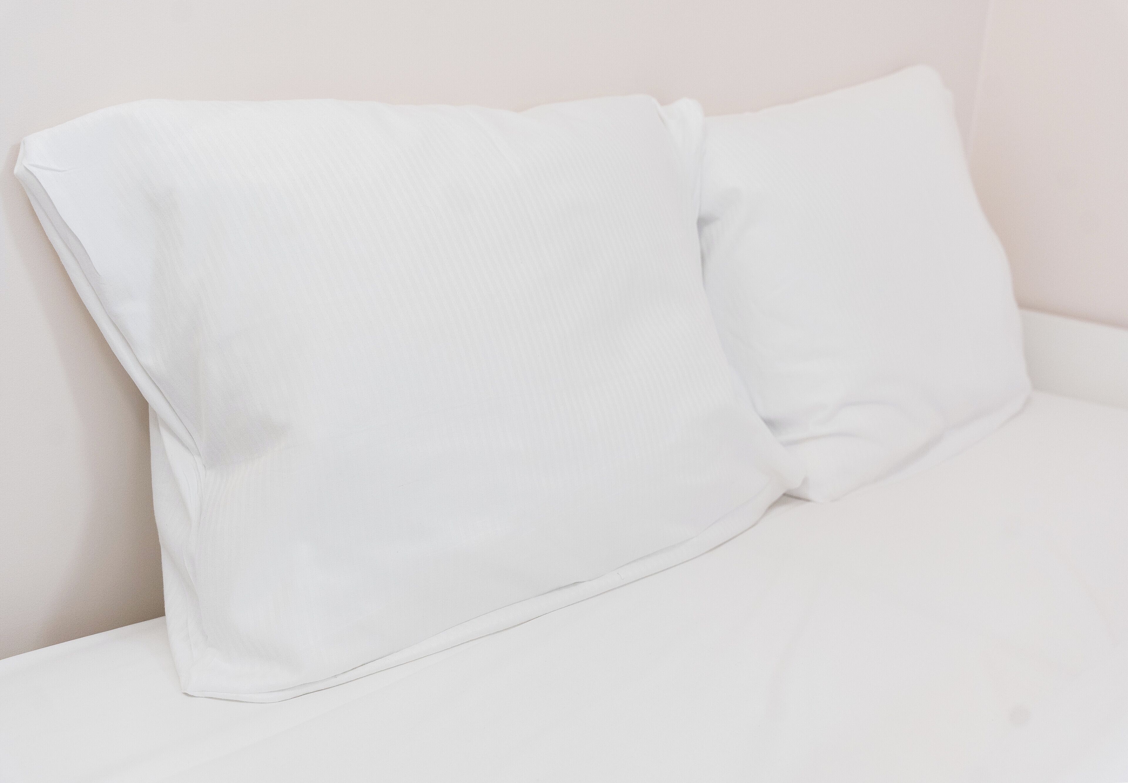 A white sofa with a matching pillow.