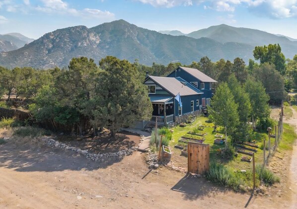 Une maison avec un grand jardin et une vue sur les montagnes.