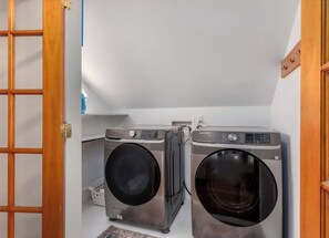 Une buanderie équipée de deux machines à laver à chargement frontal et d’un sèche-linge.