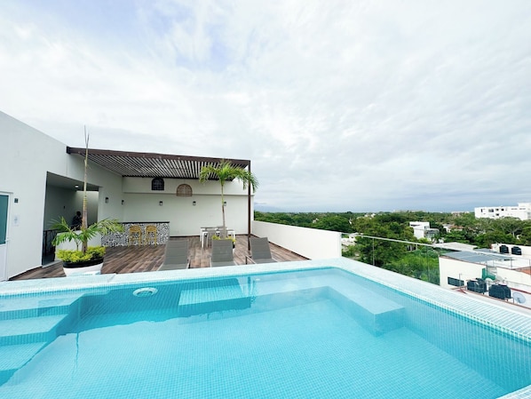 Une piscine sur le toit offrant une vue sur le paysage urbain.