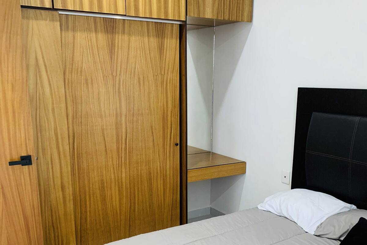 Ein Schlafzimmer mit einem Bett, einem Holzschrank und einem Nachttisch.