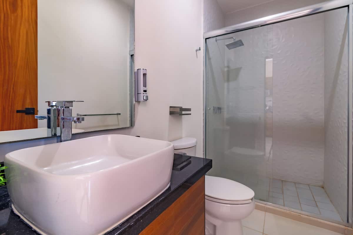 Ein modernes Badezimmer mit einer großen weißen Badewanne, einer Toilette und einer Duschkabine.